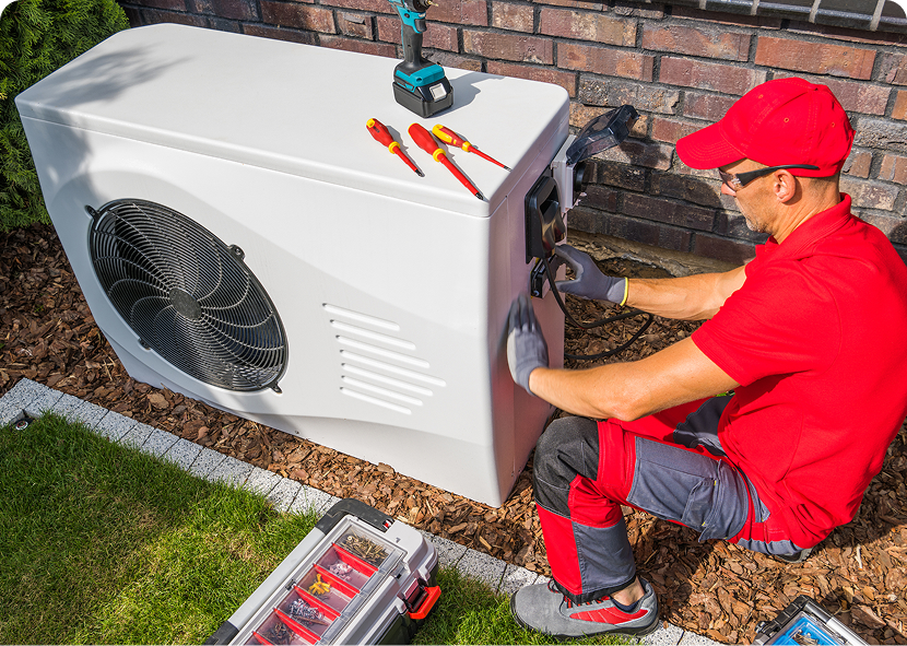 Worker servicing air conditioning system outdoors