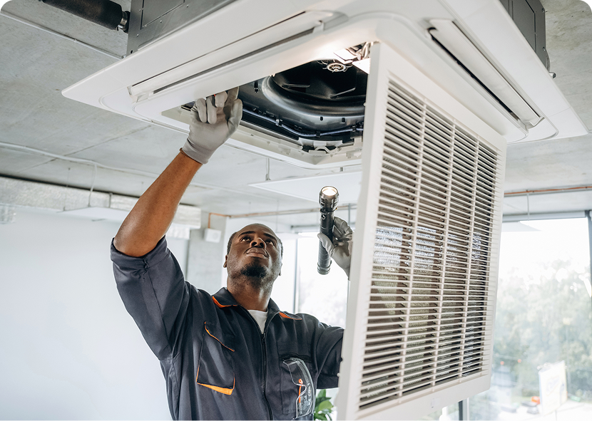 Technician repairing ceiling air conditioner unit