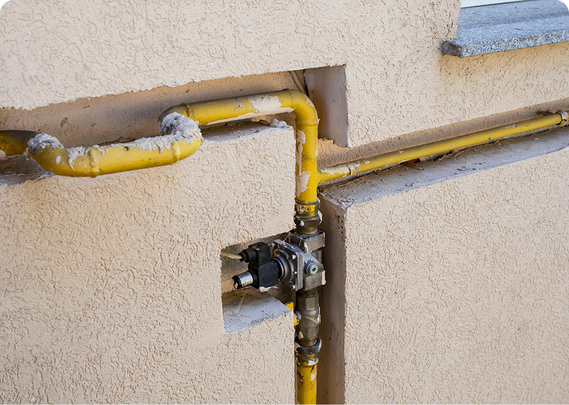 Yellow gas pipes on building wall