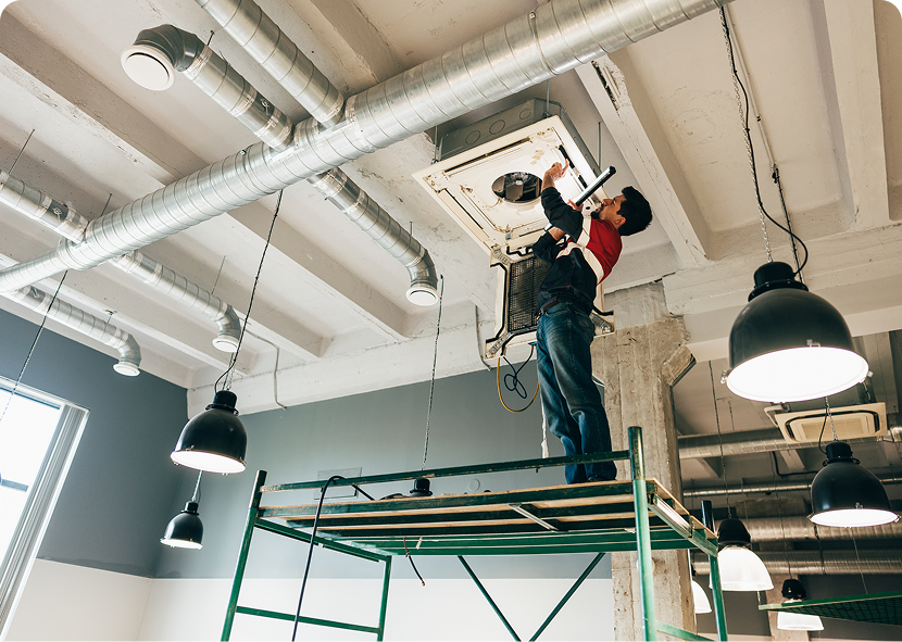 Maintenance professional servicing industrial ceiling ducts