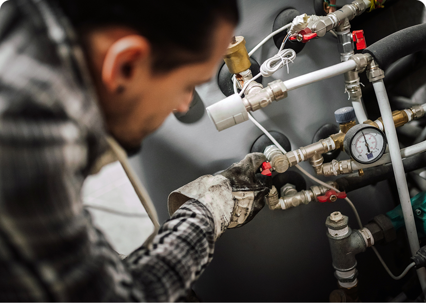 Worker inspecting complex plumbing system