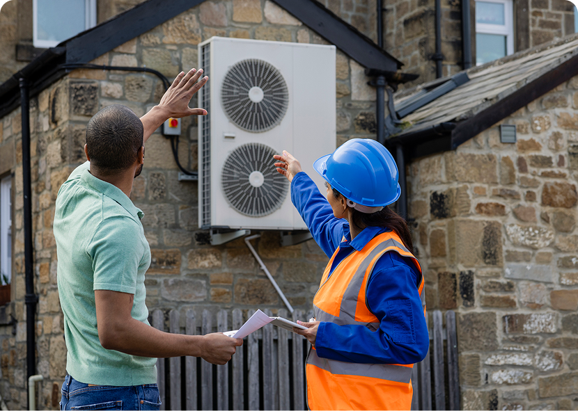 Technician in helmet discussing air conditioner.